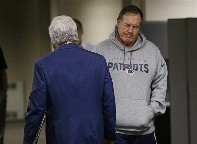 New England Patriots head coach Bill Belichick walks past owner Robert Kraft as Belichick takes to there podium after Kraft addressed reporter's during an NFL football training camp media availability at the team's facility Wednesday