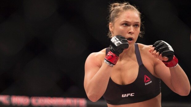 UFC women's bantamweight champion Ronda Rousey of the United States rushes forward against Bethe Correia